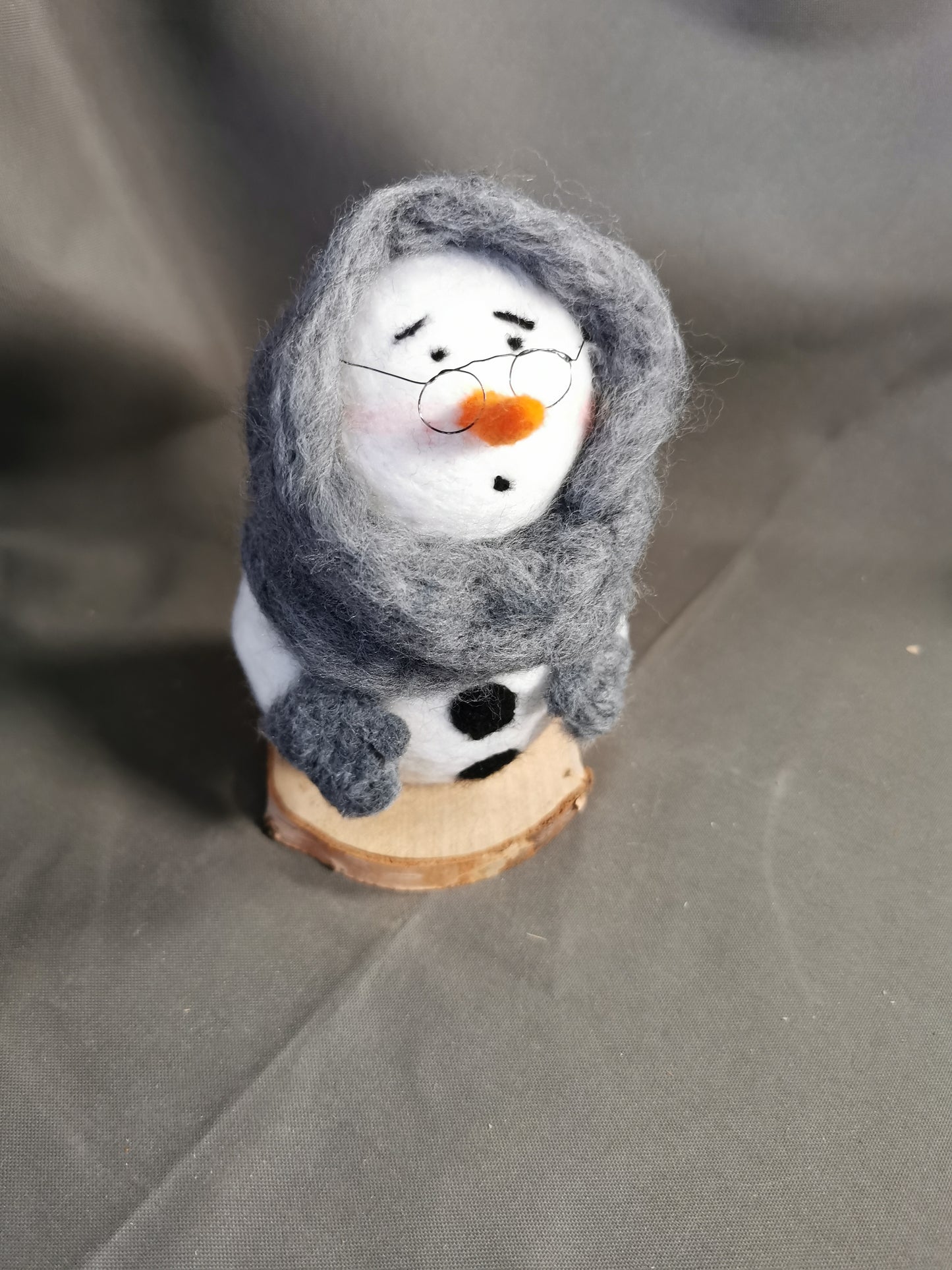 Schneemann eingehüllt in einem dicken Schal