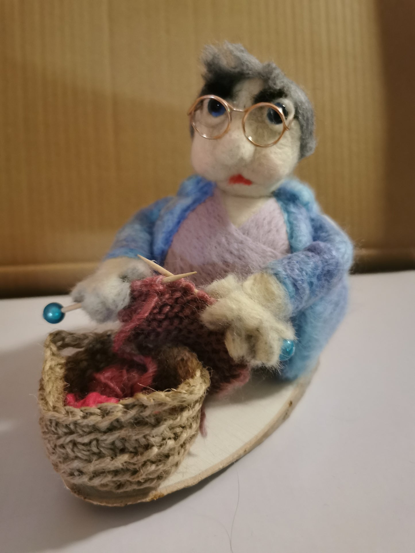 Strick Omi auf Holzscheibe