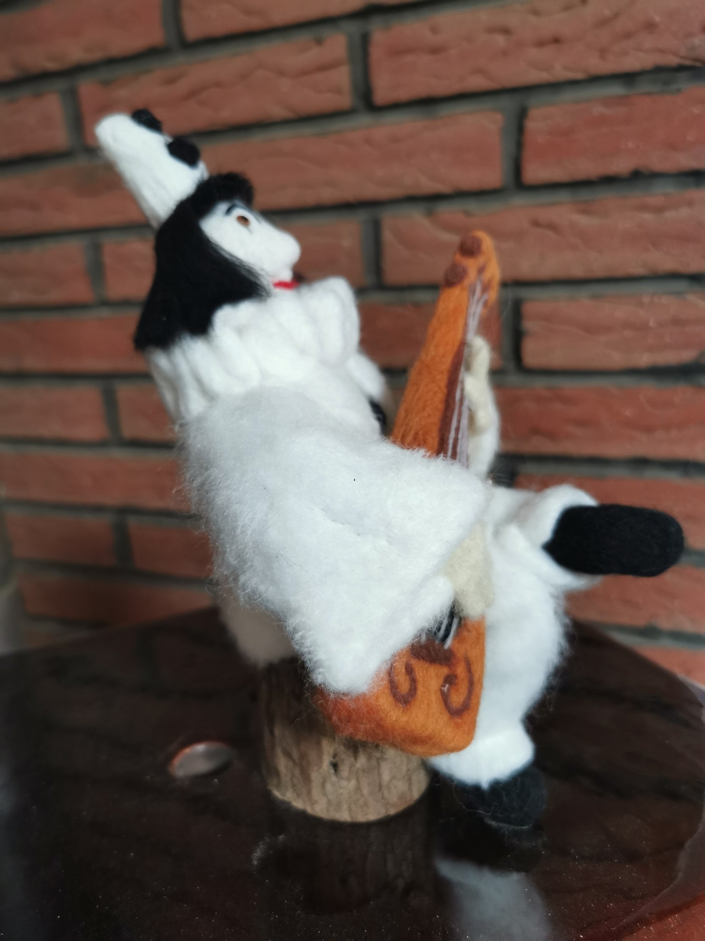 Pierrot Clown mit Gitarre auf Holzstamm
