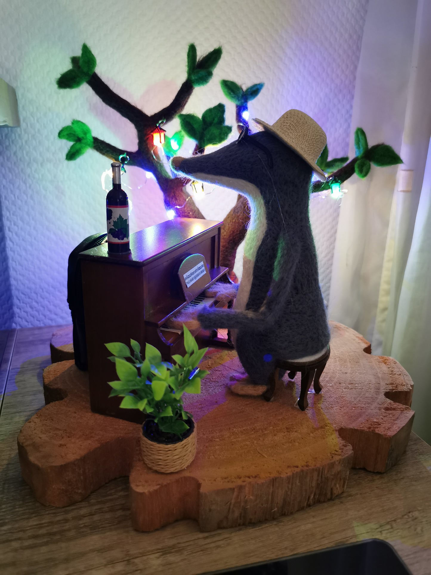 gefilzter Maulwurf am Klavier mit leuchtendem Filzbaum