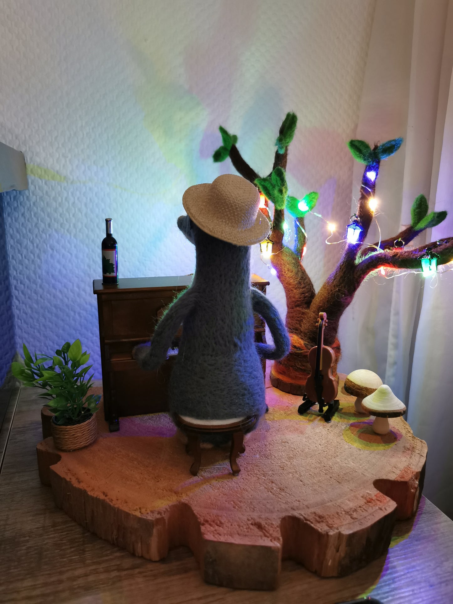 gefilzter Maulwurf am Klavier mit leuchtendem Filzbaum